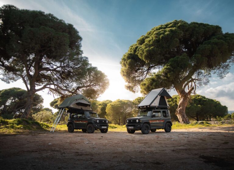 Two Suzuki Jimny Campers with rooftop tents under pine trees in Greece